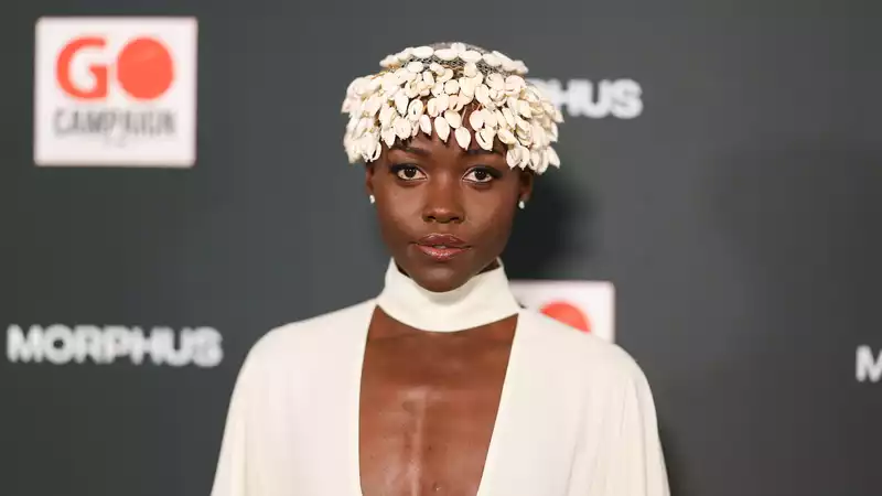 Lupita Nyongo, wearing a crown made from a cow's shell