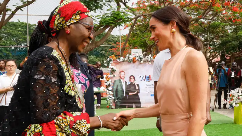 Meghan Markle shines in a sleeveless peach sundress on the first day of her visit to Nigeria.